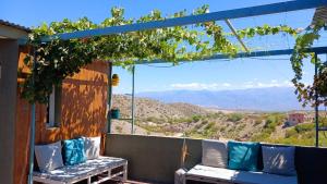 a porch with a bench and a view of the mountains at ENCUENTRO LA ÑATA in Amaicha del Valle