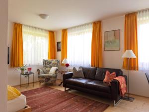 a living room with a leather couch and a chair at Apartment Denk in Bregenz +10 photos