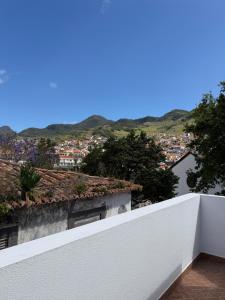 a white balcony with a view of a city at Machico Village Apartment - Private terrace & car park in Machico