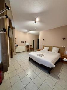 a bedroom with a large white bed and a table at Le Lion D'or in Ouroux