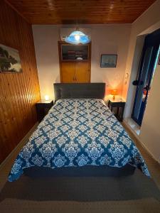 a bedroom with a bed with a blue and white bedspread at Captain's House Plomari in Plomari