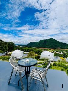 a patio with a table and two chairs and a mountain at สกายเบย์ เชียงคาน in Ban Pha Baen