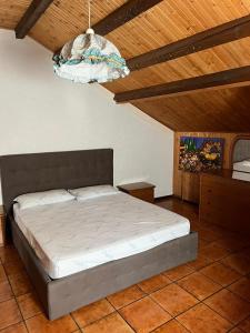 a bedroom with a bed and a chandelier at VACANZE A SESTOLA in Sestola