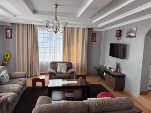 a living room with a couch and a table at Guyana Guest House in Naivasha
