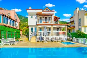 a villa with a swimming pool and a house at Summerdays in the Med in Fethiye