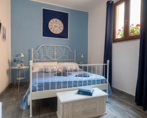 a bedroom with a bed and a clock on the wall at Domus Rubra in Castelsardo