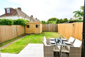 a patio with a table and chairs in a backyard at Hythe House in Hythe
