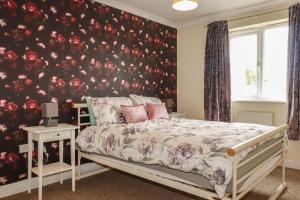 a bedroom with a bed and a floral wall at Treetops in Par