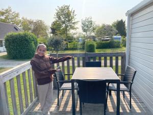 a woman standing on a porch with a table at Gilleleje Camping in Gilleleje