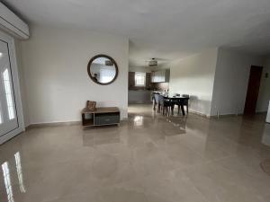 a living room with a table and a mirror on the wall at Sky Apartment in Ofrínion