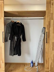 a closet with a coat hanging on a wall at Rooftop Spa Villa Kuressaare in Kuressaare