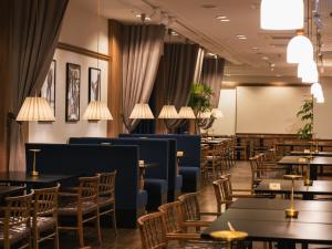 a dining room with tables and chairs and a chalkboard at Oarai Park Hotel in Oarai