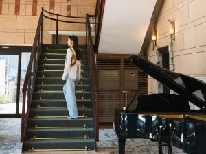 a woman is standing on the stairs at Oarai Park Hotel in Oarai