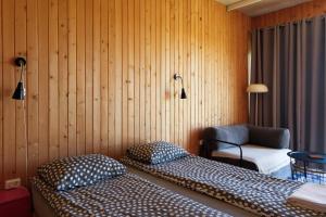 a room with two beds and a chair in it at Oasis Club Cottages in Udabno