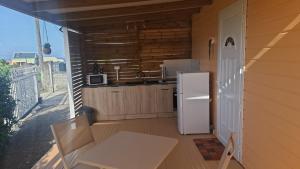 a small kitchen with a refrigerator and a sink at bungalow détente in Capesterre-Belle-Eau