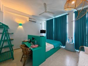 a bedroom with green curtains and a bed with a desk at Trinco Beach by DSK in Trincomalee