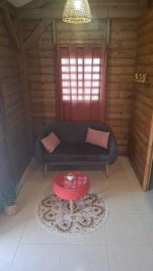 a living room with a couch and a table at bungalow détente in Capesterre-Belle-Eau