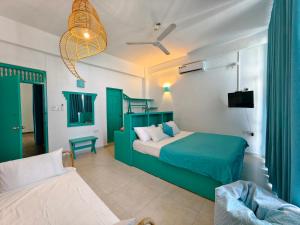 a bedroom with a green bed and a couch at Trinco Beach by DSK in Trincomalee