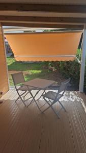 a chair and a table on a deck at bungalow détente in Capesterre-Belle-Eau