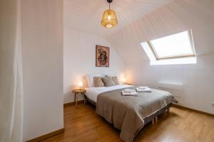 a bedroom with a bed with two towels on it at Le Triplex - cosy avec petit jardin in Longueville