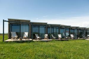 a group of chairs sitting in the grass in front of a building at Oasis Club Cottages in Udabno