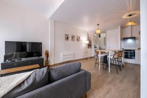 a living room with a couch and a table at Le Triplex - cosy avec petit jardin in Longueville