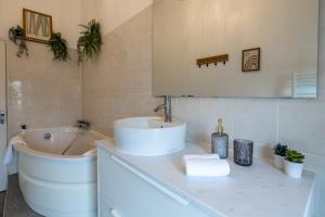 a white bathroom with a sink and a tub and a sink at Le Triplex - cosy avec petit jardin in Longueville +29 photos