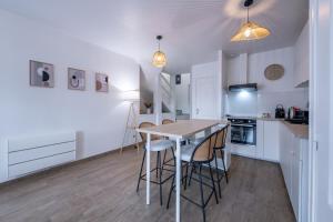 a kitchen and dining room with a table and chairs at Le Triplex - cosy avec petit jardin in Longueville