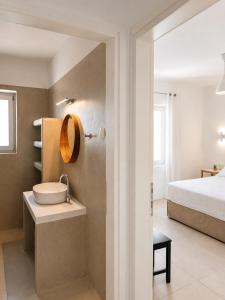 a bathroom with a sink and a bed at Aphrodite's Villa in Ambelas