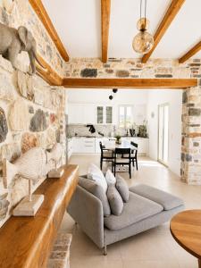 a living room with a couch and a stone wall at Aphrodite's Villa in Ambelas