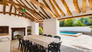 a dining room with a table and chairs and a swimming pool at Cortijo La Gineta in Alcalá la Real