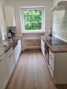 a kitchen with white cabinets and a window at Ferienwohnung Bever in Bad Karlshafen