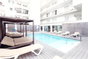 a hotel with a swimming pool and a hammock next to a building at Hotel Gracia in El Arenal