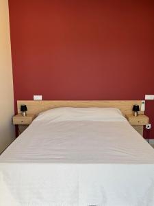 a bedroom with a white bed with a red wall at Quinta do Olival Amarante in Gatão +37 photos