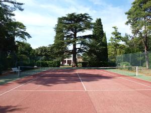 エルーにあるLa Ginelle - Maison Récantouの木を背景にしたテニスコート