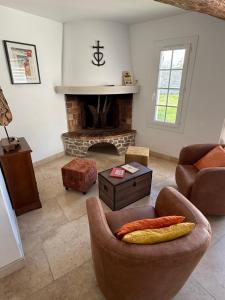 a living room with a chair and a fireplace at Domaine du Soleil Couchant in Saintes-Maries-de-la-Mer