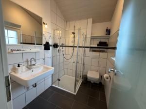 a bathroom with a shower and a sink and a toilet at Ferienhaus Burbach in Burbach +24 photos