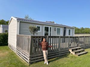 a man standing in front of a tiny house at Gilleleje Camping in Gilleleje