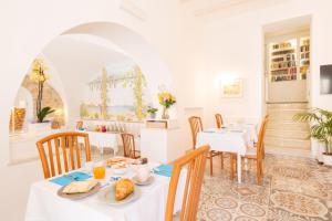 a dining room with white tables and chairs with food on them at Hotel Marconi in Sperlonga