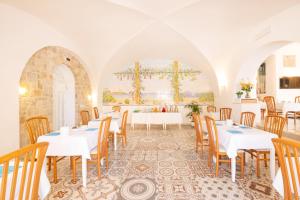 a dining room with white tables and chairs and a painting at Hotel Marconi in Sperlonga +62 photos