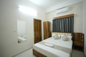 a bedroom with a bed and a mirror at Hotel Banyan Courtyard Guwahati in Guwahati