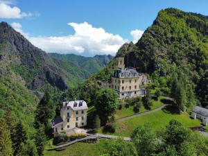 a large building on a hill in the mountains at Castle - A Magic Retreat in Fobello