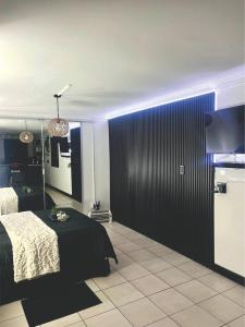 a bedroom with a bed and a black wall at Angel's Cottage Unit 2 in Paarl
