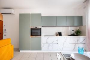 a kitchen with green and white cabinets and a table at Ca'vio Beach Pool in Cavallino-Treporti