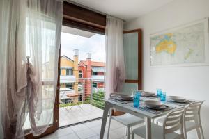 a dining room with a table and a balcony at Ca'vio Beach Pool in Cavallino-Treporti
