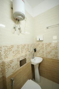 a bathroom with a white toilet and a sink at Hotel Banyan Courtyard Guwahati in Guwahati +26 photos