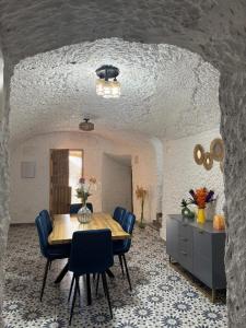 a dining room with a table and blue chairs at Cueva Pilar in Graena