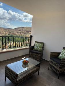 a living room with two chairs and a table and a large window at Cueva Pilar in Graena