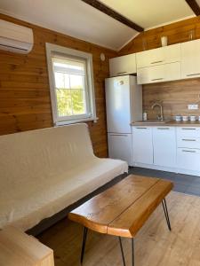 a kitchen with a couch and a table in a room at Rajskie Domki in Sadowie +27 photos