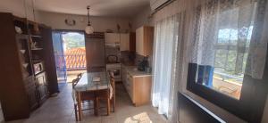 a small kitchen with a table and a window at Hill View in Nikiti +25 photos